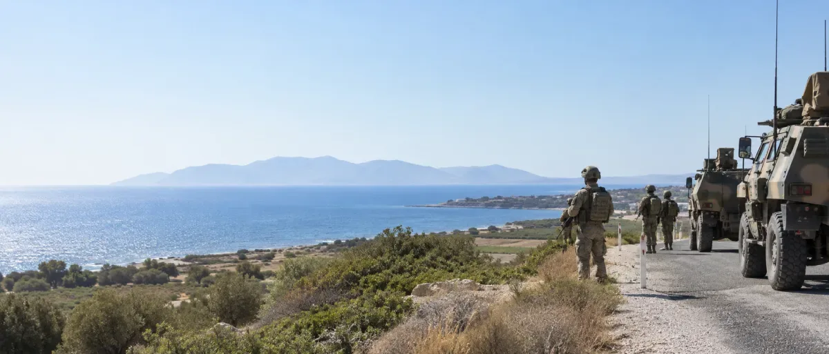 Turkish armored vehicles and commandos on a coastal road near Söke, overlooking the Aegean Sea with Samos visible in the distance