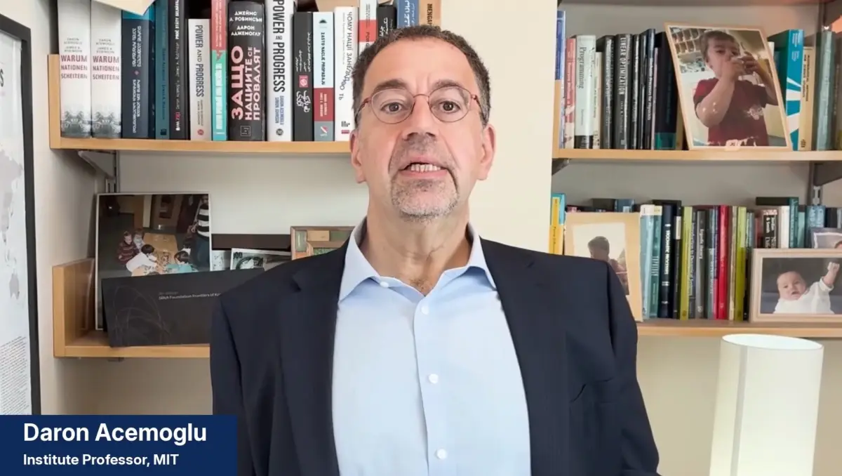 Daron Acemoglu speaking with bookshelves in the background