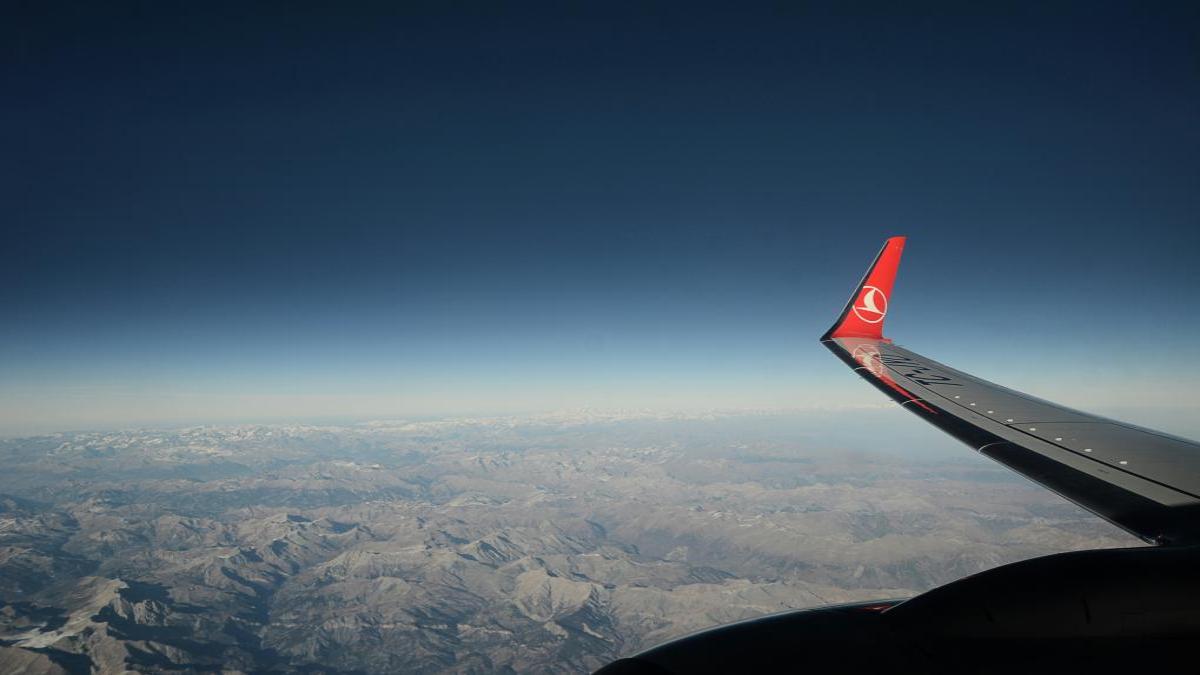 View from a Turkish Airlines cabin window showing the wingtip against the sky at cruising altitude