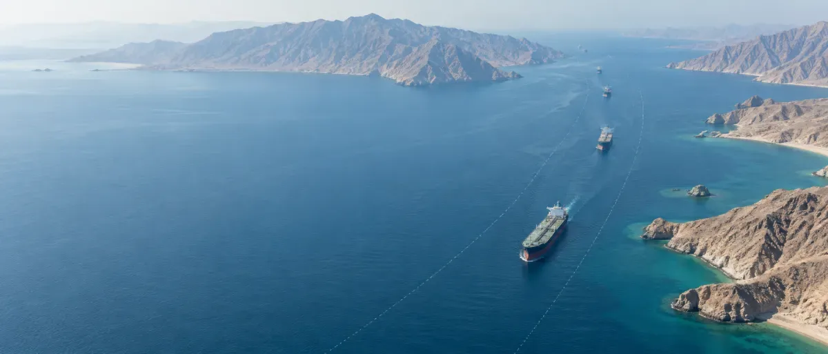 Editorial illustration of oil tankers moving through the Strait of Hormuz between Iran and Oman