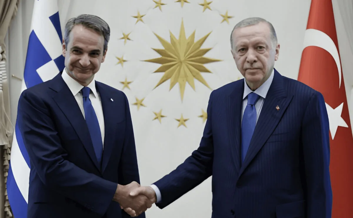 Greek and Turkish leaders shaking hands during a bilateral meeting with their national flags behind them