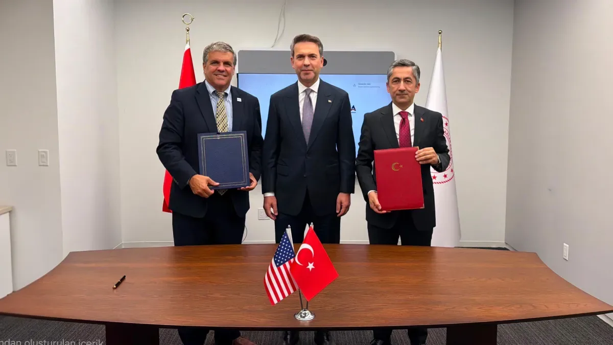 Turkish and US officials pose with signed agreement folders beside the two countries’ flags after the TÜNAŞ-USTDA nuclear cooperation agreement
